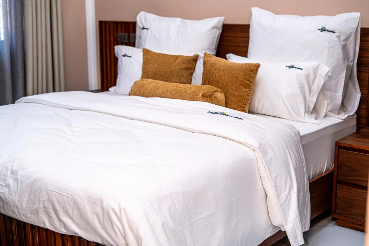 Chambre meublée avec linge blanc et coussins dorés